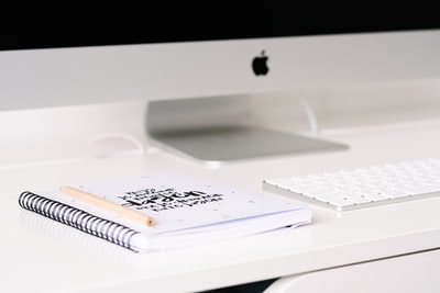 白皮书iMac和键盘在桌子旁边
